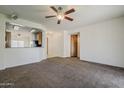 Open-concept living room with carpet flooring, a ceiling fan, and views of the kitchen at 2778 E Devon Ct, Gilbert, AZ 85296