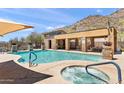 A pristine community pool and hot tub are surrounded by luxurious lounging, set against desert mountain views at 36600 N Cave Creek Rd # 9B, Cave Creek, AZ 85331