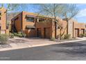 Charming two-story condo showcasing its earthy tones, three-car garage, and lush landscaping at 36600 N Cave Creek Rd # 9B, Cave Creek, AZ 85331