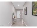 Clean and bright hallway features neutral paint, tile flooring, and decor at 36728 N Alderney Ct, San Tan Valley, AZ 85143