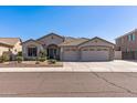 Lovely single-story home featuring a three-car garage and desert landscaping with a tile roof at 7329 W Tether Trl, Peoria, AZ 85383