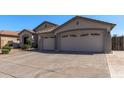 Spacious three-car garage with decorative windows and a tile roof on a single-story home at 7329 W Tether Trl, Peoria, AZ 85383