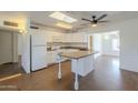 Bright kitchen features a skylight, white cabinets, and a center island with modern fixtures at 7737 W Medlock Dr, Glendale, AZ 85303