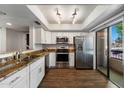 Beautiful kitchen features white cabinets, stainless steel appliances, granite counters, and wood flooring at 9445 N 94Th Pl # 212, Scottsdale, AZ 85258
