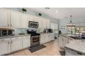 Bright kitchen with white cabinets, granite countertops, stainless steel appliances, and tile flooring at 11121 N 165Th Ave, Surprise, AZ 85388