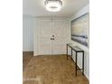 Elegant entryway featuring double doors, a modern light fixture, and stylish decor at 15218 N 37Th Ave, Phoenix, AZ 85053