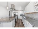 Kitchen with white cabinets, gray countertops, stainless steel appliances, and wood-style flooring at 15848 N 32Nd Pl, Phoenix, AZ 85032