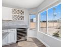 Kitchen area showcasing a built-in wine fridge and ample natural light from the window at 15848 N 32Nd Pl, Phoenix, AZ 85032