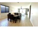 Open-concept living area with dining table, stylish furniture, and abundant natural light at 17829 W Red Fox Rd, Surprise, AZ 85387