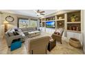 A spacious living room features built-in shelving, a large window, and comfortable seating at 18102 N Petrified Forest Dr, Surprise, AZ 85374