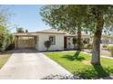 Well-maintained single-story home featuring a spacious driveway and a covered parking area at 2163 W Flower St, Phoenix, AZ 85015