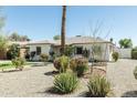 Desert landscape featuring lush plants in front of the cozy single-story home at 2163 W Flower St, Phoenix, AZ 85015