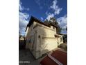 Shows a side view of a house with a stucco exterior and an attached garage at 2521 N 89Th Ave, Phoenix, AZ 85037