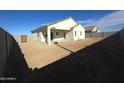 View of backyard showing a blank slate yard, covered patio, and block wall fencing at 26409 W Desert Crest St, Casa Grande, AZ 85193