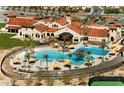 Aerial view of a resort-style community pool with umbrellas, palm trees, and ample seating at 26664 W Siesta Ln, Buckeye, AZ 85396