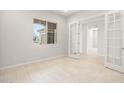Bright office space with neutral tones and tile flooring features modern french doors at 26664 W Siesta Ln, Buckeye, AZ 85396