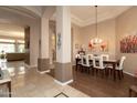 Elegant dining room with a modern chandelier, decorative pillars, and an adjoining living space at 301 E Ashurst Dr, Phoenix, AZ 85048