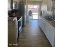 Bright kitchen featuring white cabinets and wood floors, with access to the backyard at 3431 W Campbell Ave, Phoenix, AZ 85017