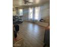 Comfortable living room with wood floors, bright windows, and a ceiling fan at 3431 W Campbell Ave, Phoenix, AZ 85017