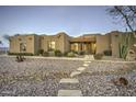 Inviting desert home featuring natural landscaping and a quaint tile pathway to the entrance at 39657 N Foxtail Ln, San Tan Valley, AZ 85140