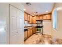 Bright kitchen with stainless steel appliances, tan cabinets, and stone countertops at 4354 N 82Nd St # 182, Scottsdale, AZ 85251