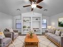 Bright living room featuring vaulted ceilings, built-in shelving, and plush neutral furnishings at 573 W Rattlesnake Pl, Casa Grande, AZ 85122