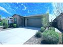 Beautiful single-story home featuring a stone facade, a concrete driveway and manicured landscaping at 9413 W Devonshire Ave, Phoenix, AZ 85037