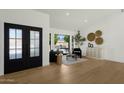 Bright living room with a large picture window, wood floors, and modern furnishings at 10013 N 106Th Pl, Scottsdale, AZ 85258