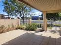 Covered tiled patio with privacy wall, and views to mature trees and well-manicured landscaping at 11108 W Cameo Dr, Sun City, AZ 85351