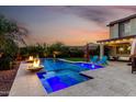 Outdoor living with a sparkling pool, ambient lighting, and cozy seating under a star filled sky at 12055 W Nadine Way, Peoria, AZ 85383