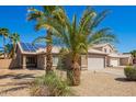 Charming single-story home with a two car garage and desert landscaping with beautiful palm trees at 12622 W Catalina Dr, Avondale, AZ 85392