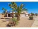 Charming single-story home with a two car garage and desert landscaping with beautiful palm trees at 12622 W Catalina Dr, Avondale, AZ 85392