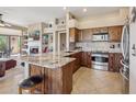 Open concept kitchen with stainless appliances, granite counters, tile backsplash and breakfast bar at 13013 N Panorama Dr # 120, Fountain Hills, AZ 85268