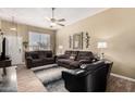 Comfortable living room with plush seating, ceiling fan, wood-look flooring, and natural light at 14212 N Newcastle Dr, Sun City, AZ 85351