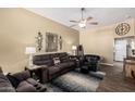 Cozy living room with comfortable seating, ceiling fan, stylish decor, and wood-look flooring at 14212 N Newcastle Dr, Sun City, AZ 85351