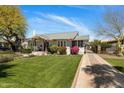 Well-manicured lawn leads to the charming home featuring a red door and inviting porch at 144 W Palm Ln, Phoenix, AZ 85003
