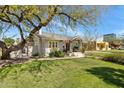 Landscaped front yard with a well-maintained lawn and mature shade tree at 144 W Palm Ln, Phoenix, AZ 85003