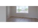 Bright, empty living room with wood floors and a large window overlooking the street at 14803 N 55Th Ave, Glendale, AZ 85306