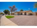 Attractive single-story home with desert landscaping, a two-car garage, and a well-maintained lawn at 15022 N 22Nd Ln, Phoenix, AZ 85023