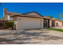 Spacious two-car garage of a single-story home, complemented by desert landscaping and a well-maintained exterior at 15022 N 22Nd Ln, Phoenix, AZ 85023