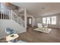 Open-concept living room with a staircase, dining area, and plenty of natural light at 18123 W Lundberg St, Surprise, AZ 85388