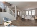Bright living room features modern flooring, neutral colors, and a staircase with white banisters at 18123 W Lundberg St, Surprise, AZ 85388