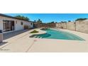 Backyard pool with waterfall feature, concrete patio, and partial view of home at 1922 W Joan De Arc Ave, Phoenix, AZ 85029