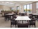 Modern designed clubhouse interior with tables, chairs and floor-to-ceiling windows viewing the community pool at 2121 W Sonoran Desert Dr # 126, Phoenix, AZ 85085