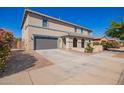 Wide view of a large home showcasing a gray garage door and a neatly landscaped front yard at 21256 E Waverly Dr, Queen Creek, AZ 85142