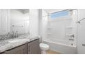 Clean bathroom showcasing a granite countertop, an undermount sink, and a shower-tub combo with a window at 21287 N 272Nd Ln, Buckeye, AZ 85396