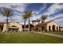 Beautifully landscaped community building with green lawn and palm tree lined walkway at 21287 N 272Nd Ln, Buckeye, AZ 85396