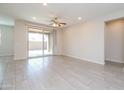 Spacious living room featuring tile floors, ceiling fan, and access to backyard patio at 22463 E Rosa Rd, Queen Creek, AZ 85142