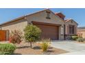 Single-story home showcasing desert landscaping, a paved driveway, and a tile roof at 2424 S 235Th Dr, Buckeye, AZ 85326
