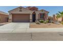 Single-story home featuring a desert landscape, attached two car garage, and tile roof at 2424 S 235Th Dr, Buckeye, AZ 85326